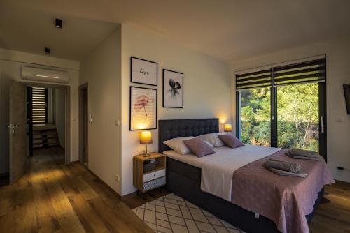 a bedroom with a large bed and a window at Villa Hedona in Komarna