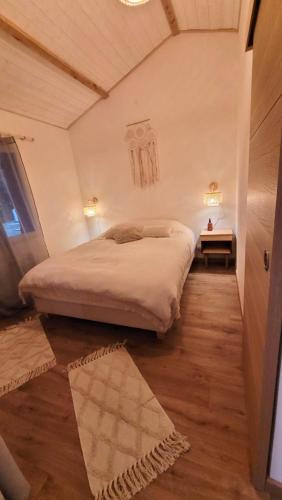une chambre avec un grand lit dans une pièce dans l'établissement Le Cosy Porgeais, à Le Porge