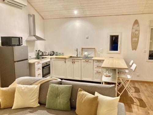 un salon avec un canapé et une cuisine dans l'établissement Le Cosy Porgeais, à Le Porge
