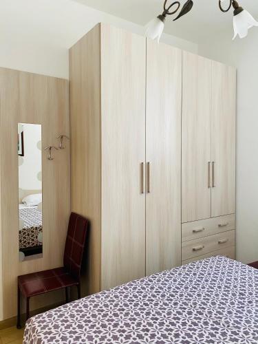 - une chambre avec un lit, une chaise et un miroir dans l'établissement Casa Vacanza di Iside, à Montegiordano