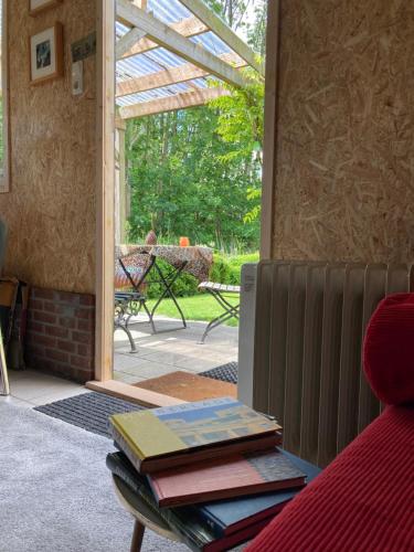 a living room with a table with books on it at Vakantiehuisje De Waddenuil in Usquert
