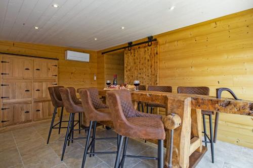 a kitchen with a bar with stools and wooden walls at L'Atipik - Welkeys in Bénesse-Maremne