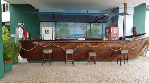 un bar con taburetes frente a una pecera en Angra Inn - Praia Grande 318, en Angra dos Reis