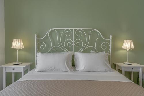 a bed with a green headboard and two lamps at Patrinos Studios in Alikanas