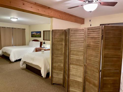 Whitetail Creek Resort في Lead: غرفة فندقية بسريرين ومروحة سقف