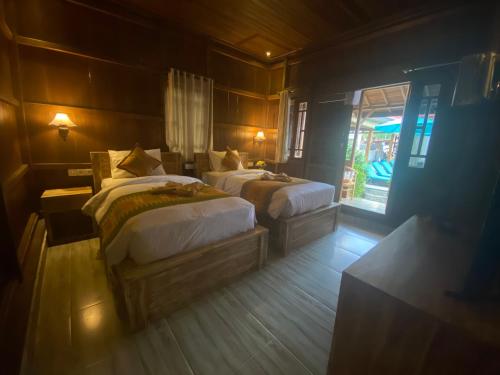 a bedroom with two beds and a window at Grand Cory in Nusa Penida