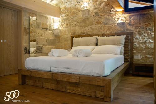 een slaapkamer met een groot bed in een stenen muur bij 500 Home in Castrignano deʼ Greci