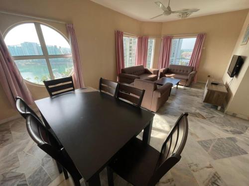 a living room with a table and chairs and a couch at Fullhouse Marina View Villas Apartment in Port Dickson