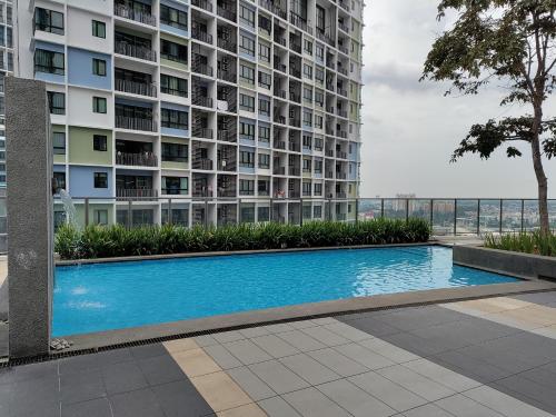 a swimming pool in front of a tall building at Wadi Iman Guesthouse @ i-City in Shah Alam