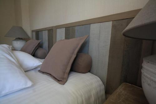 a bed with two pillows on top of it at Logis Hôtel Restaurant Le Domaine de l'Eau Vive in Largentière