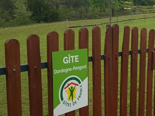 a sign on a fence in front of a field at Maison périgourdine avec jacuzzi, jardin privé et vélos - Idéal 2 personnes, près de Sarlat - FR-1-616-209 in Le Bugue