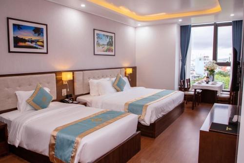 a hotel room with two beds and a window at SALA HOTEL MÓNG CÁI in Móng Cái