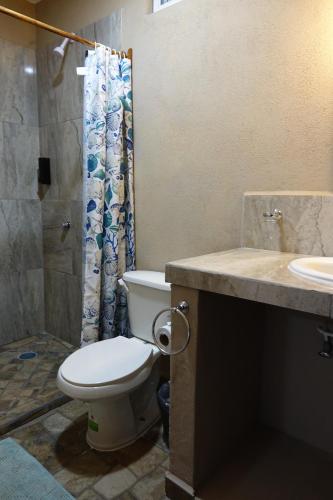 uma casa de banho com um WC, um chuveiro e um lavatório. em Bungalows Victoria em La Manzanilla