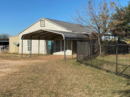 a house with a fence in front of a building at Opa's House in Abilene