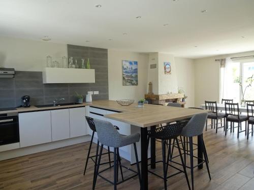 une cuisine avec une table et des chaises dans une pièce dans l'établissement Comfortable Bungalow, Pink Granite Coast, à Pleumeur-Bodou