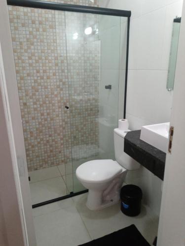 a bathroom with a toilet and a glass shower at Hotel Pousada Santa Maria in Aparecida