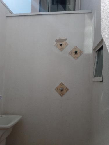 a bathroom with three lights on the wall at Hotel Pousada Santa Maria in Aparecida
