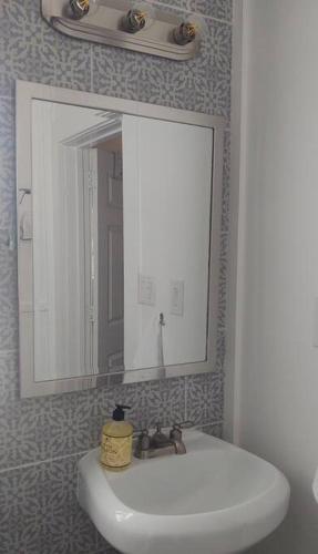 a bathroom with a white sink and a mirror at Oma's House on Orange in Abilene