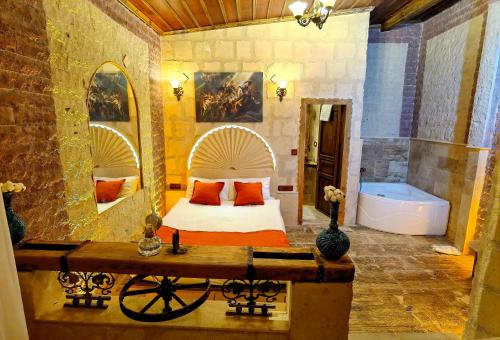 a bedroom with a bed and a tub in a room at Larissa Cave Hotel in Nevşehir