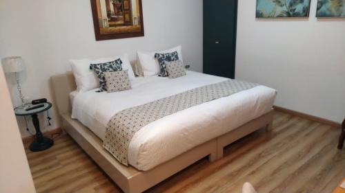 a bedroom with a large white bed with pillows at Adamas House Hotel Boutique in Quito