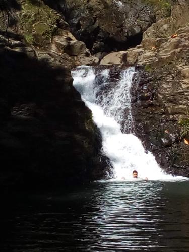 a person in the water in front of a waterfall at Les Naïades in Goyave