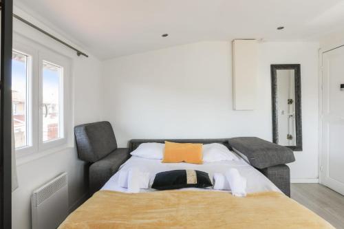 - une chambre avec un lit et un oreiller orange dans l'établissement Beau studio refait à neuf en plein coeur de Nice - Welkeys, à Nice