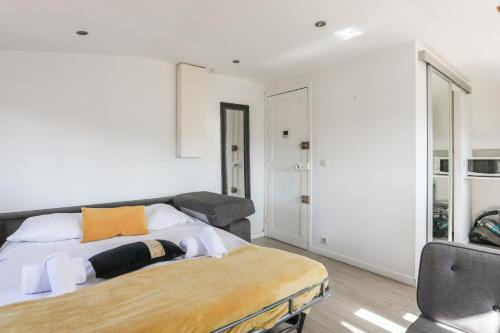 une chambre avec un lit et une chaise dans l'établissement Beau studio refait à neuf en plein coeur de Nice - Welkeys, à Nice