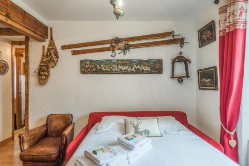 a bedroom with a bed and a chair at Appartement de l'Alpage - Welkeys in Megève