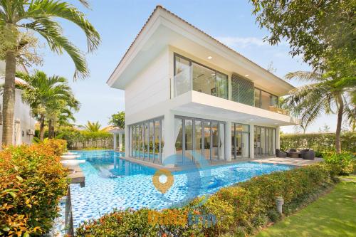 a house with a swimming pool in front of a house at Deluxe Beach Villas by Danatrip in Da Nang