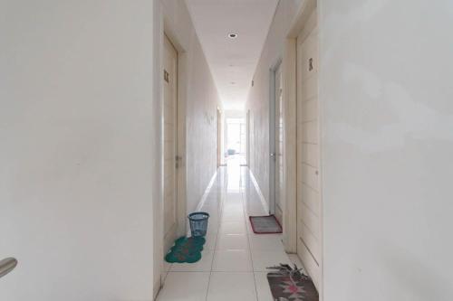 a hallway with white walls and a white tile floor at KoolKost Syariah near Alun Alun Tasikmalaya (Minimum Stay 30 Nights) in Tasikmalaya