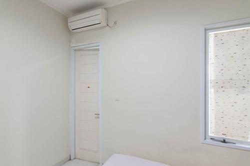 a white room with a window and a toilet at KoolKost Syariah near Alun Alun Tasikmalaya (Minimum Stay 30 Nights) in Tasikmalaya