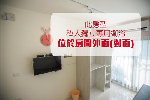 a sign for a living room with a tv and a shelf at A Day in Lukang Homestay in Lugang