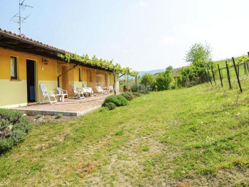 a house with a yard with chairs and a fence at Belvilla by OYO Casa Reale Due in Valdamonte