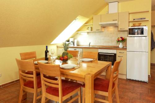 eine Küche mit einem Holztisch mit Stühlen und einem weißen Kühlschrank in der Unterkunft Haus Grete Wohnung 16 in Ostseebad Koserow