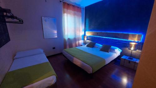 a small bedroom with two beds and a blue light at Marconi Rooms and Apartments in Verona