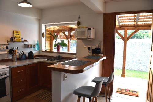 a kitchen with a counter and some chairs in it at Gîte MAZUR in Saint-Claude