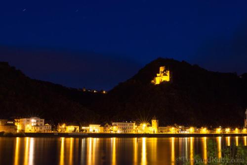 a castle on top of a mountain at night at Hotel an der Fähre in Sankt Goar