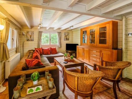 een woonkamer met een bank en een tafel en stoelen bij Spacious chalet with sauna and bubble bath in Barvaux