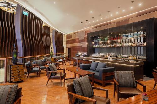 a restaurant with a bar with chairs and tables at Hyatt Regency Manila City of Dreams in Manila