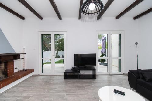 a living room with a tv and a fireplace at Villa Mungo in Starigrad-Paklenica