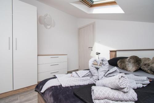 a bedroom with a bed with a pile of blankets at Villa Mungo in Starigrad-Paklenica