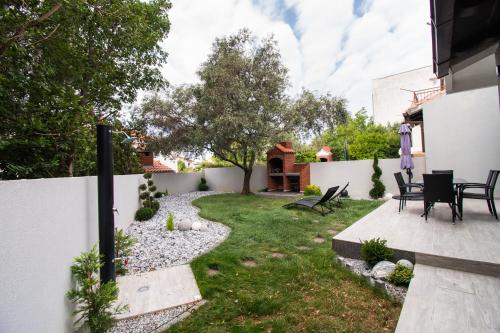 a backyard with a garden with chairs and a fence at Villa Mungo in Starigrad-Paklenica