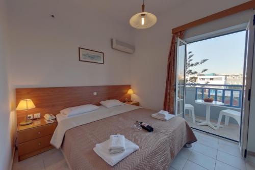 a bedroom with a bed and a balcony with a view at Marirena Hotel in Amoudara Herakliou