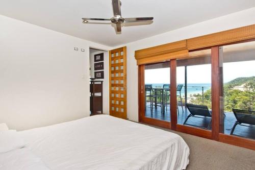 天閣露瑪的住宿－Tangalooma Hilltop Haven，一间卧室配有一张床,享有海景