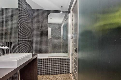 a bathroom with a shower and a sink and a tub at Tangalooma Hilltop Haven in Tangalooma