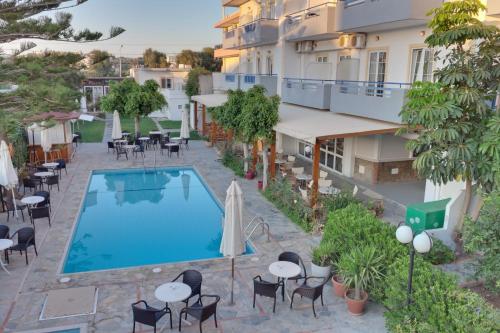 an aerial view of a hotel with a pool and tables and chairs at Marirena Hotel in Amoudara Herakliou