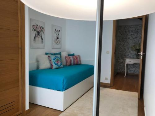 uma pequena cama num quarto com um espelho em Duplex-Ático Cangas do Morrazo em Cangas