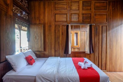 a bedroom with a bed with two cats on it at RedDoorz Syariah near Terminal Mendolo Wonosobo 2 in Ngasinan