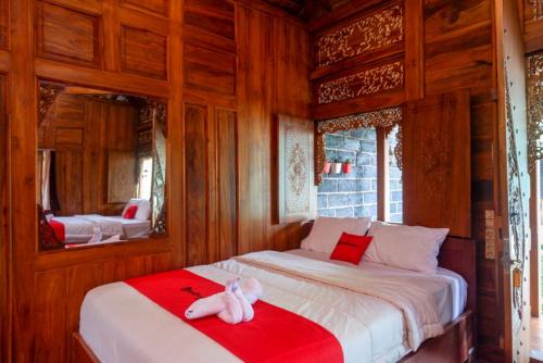 a bedroom with two beds with red and white sheets at RedDoorz Syariah near Terminal Mendolo Wonosobo 2 in Ngasinan