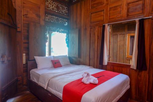 a teddy bear sitting on a bed in a room at RedDoorz Syariah near Terminal Mendolo Wonosobo 2 in Ngasinan
